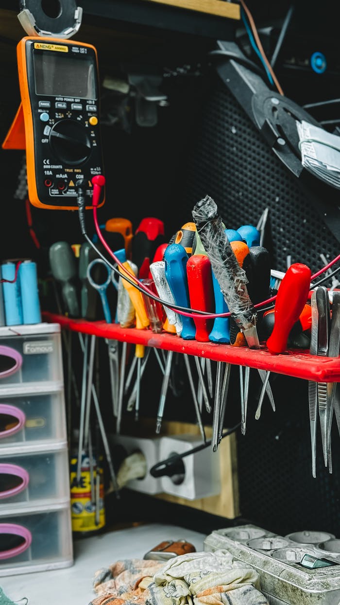 Neatly arranged tools on a workbench, featuring pliers, screwdrivers, and a multimeter.